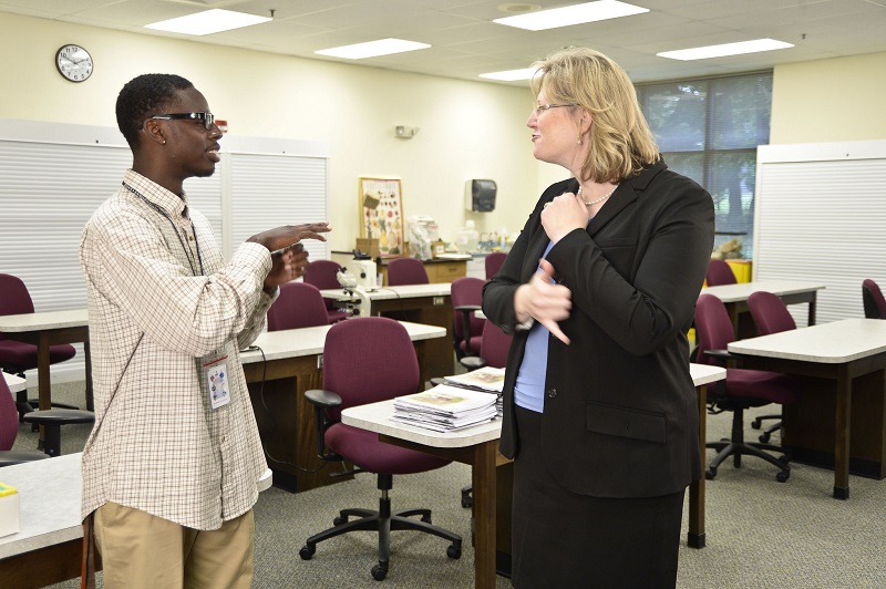 Deaf student and teacher signing in classroom.