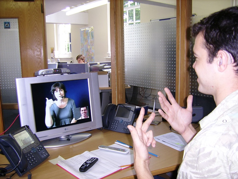 Deaf man signing to video relay communication assistant.